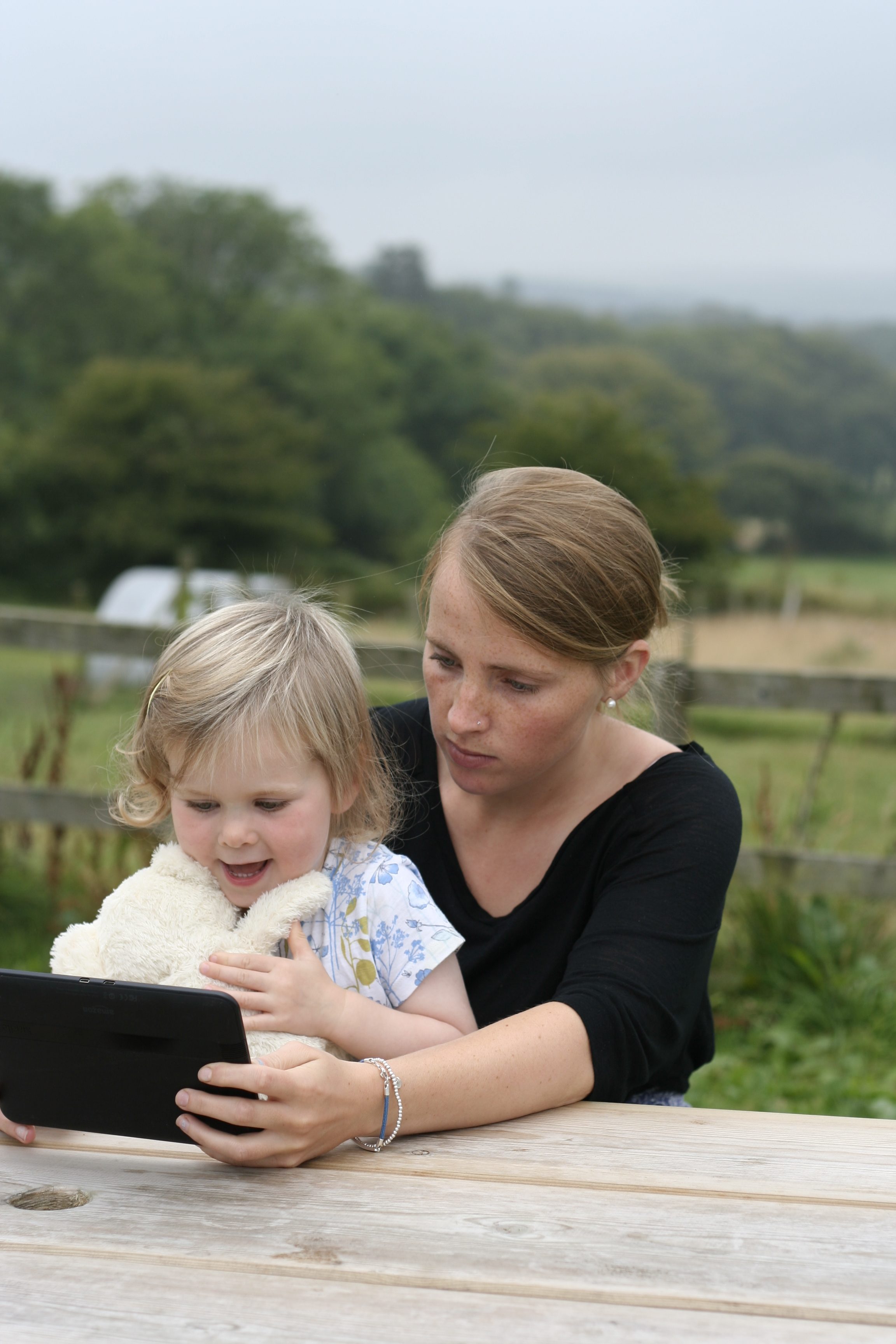picture of child and parent reading storytime teddy in the garden